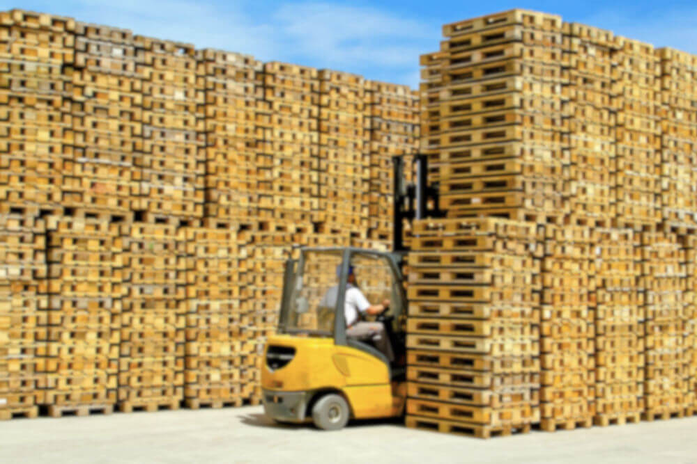 Towering stacks of beautiful wooden pallets, and a man on his
     forklift pondering the many possibilities.